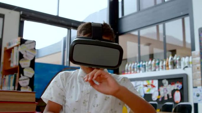 在学校4k教室里使用虚拟现实耳机的亚洲男生的前视图