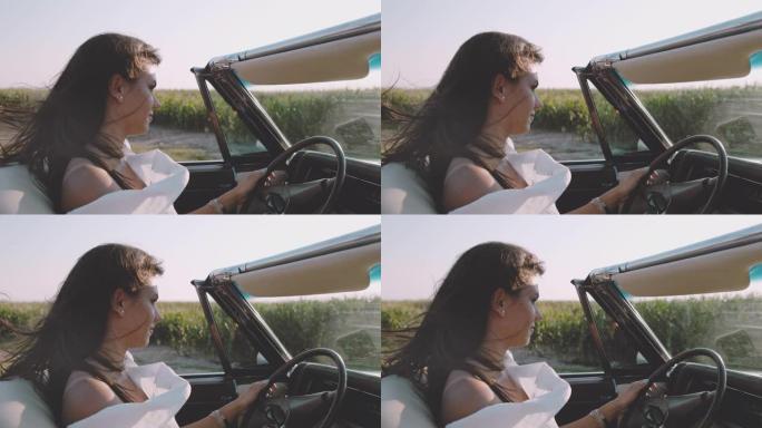 SLO MO-TIME翘曲效果无忧无虑的年轻女子沿着阳光明媚的乡村田野驾驶敞篷车