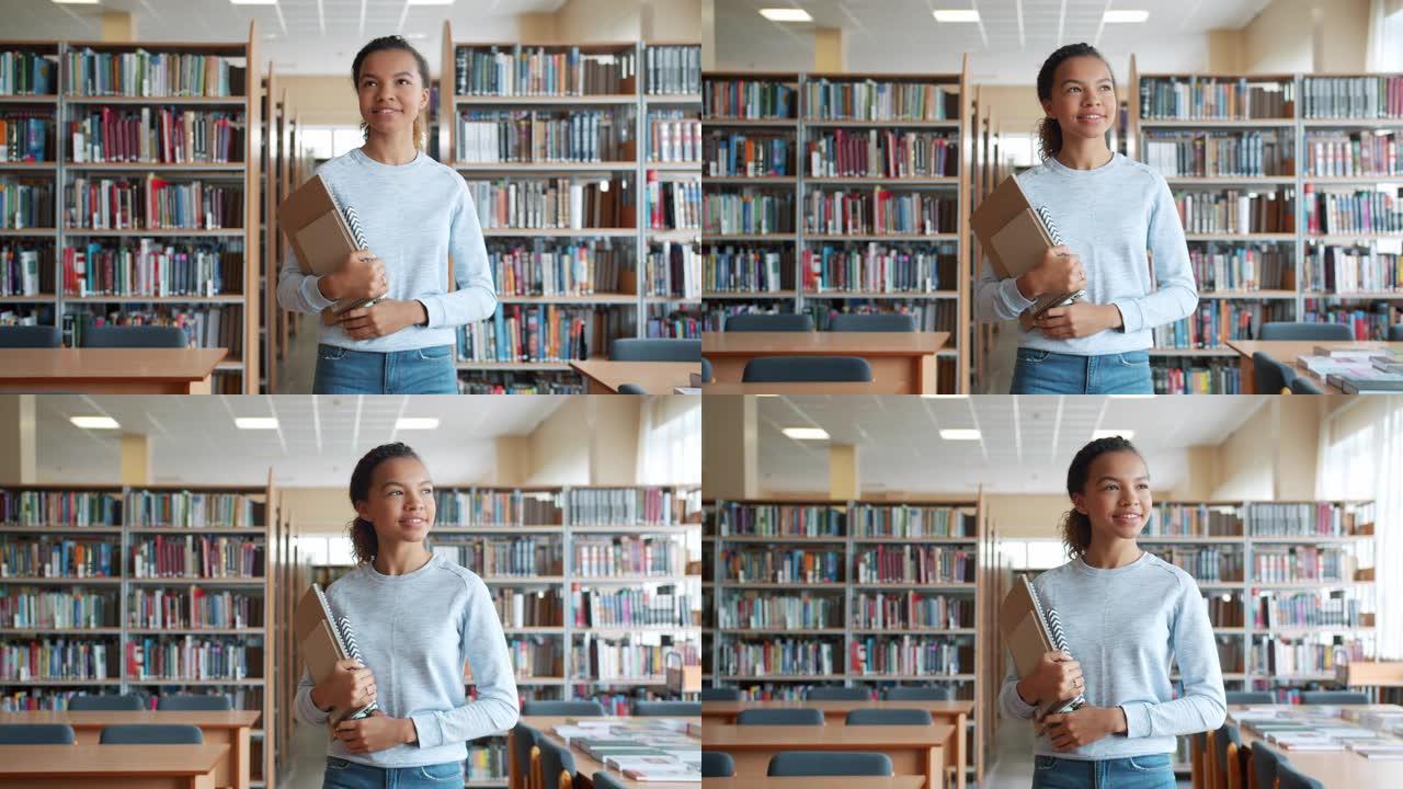 开朗的十几岁的女孩在高中图书馆微笑着走路