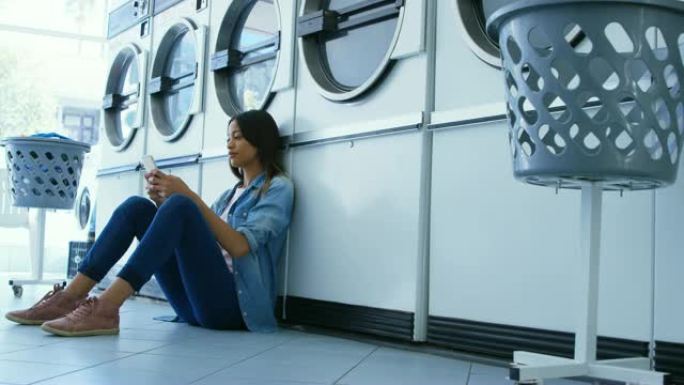 在4k自助洗衣店使用手机的女人