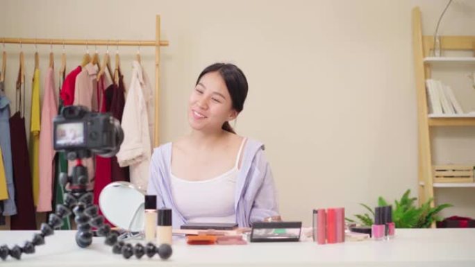 美容博主呈现美容化妆品坐在前置摄像头录制视频。快乐美丽的年轻亚洲女人使用化妆品评论化妆教程直播视频到