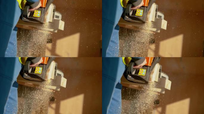 特写: 工人使用电锯将光束切成两块的详细镜头。