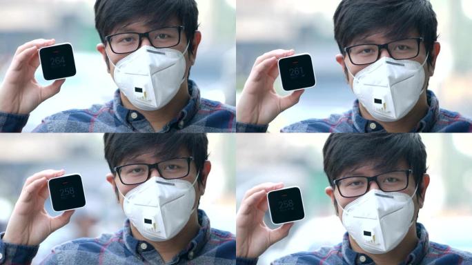4K CU亚洲男子戴口罩显示空气质量检测器监测污染计