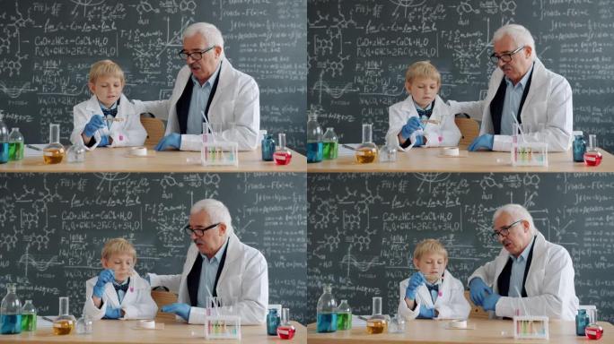 小男孩在学校进行化学测试，而老师则帮助解释