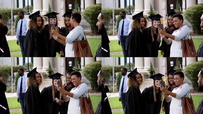 女大学毕业生的妈妈向女儿和她的朋友展示毕业照