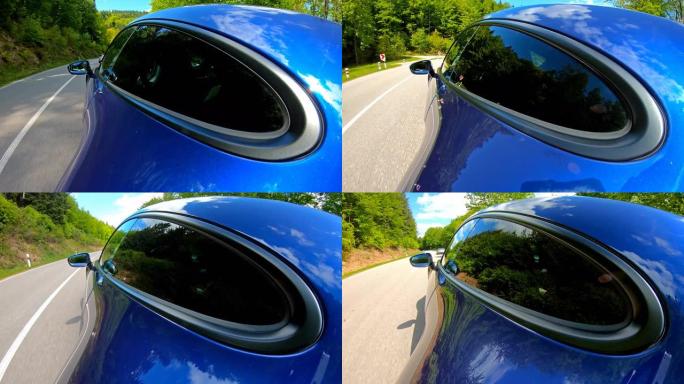 在美丽的晴天，驾驶一辆优雅豪华的蓝色跑车在风景如画的道路上行驶
