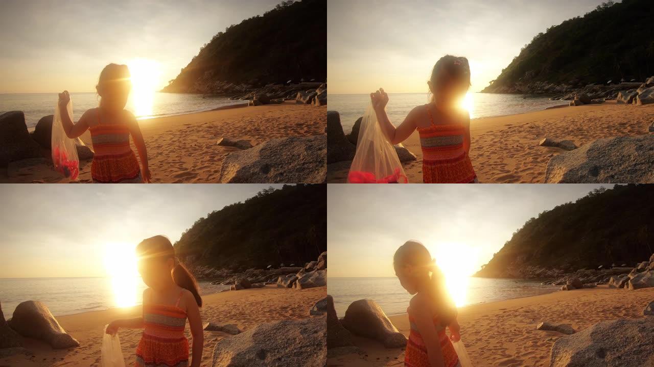 快乐的儿童女孩在日落时在美丽的海滩上玩耍
