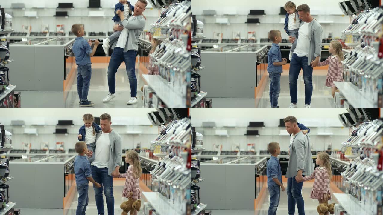 爱心爸爸在购物中心与小女儿和儿子交谈