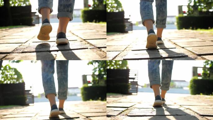 女人腿的特写镜头用阳光行走，慢动作