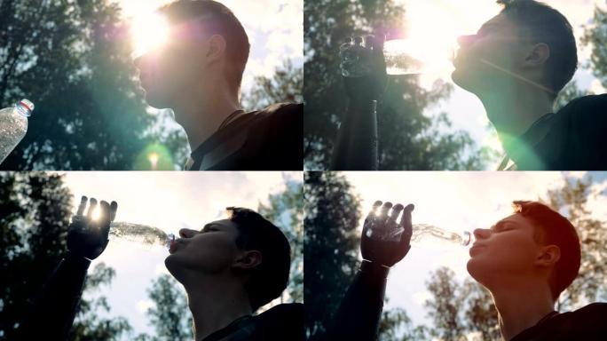 男人在天空背景上喝水，底部视图。