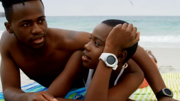 非裔美国夫妇在4k海滩上放松的前视图