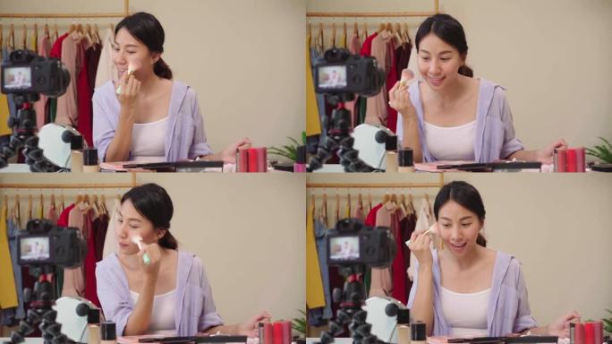 慢动作-美容博主介绍美容化妆品坐在前置摄像头中录制视频。快乐美丽的年轻亚洲女人使用化妆品评论化妆教程