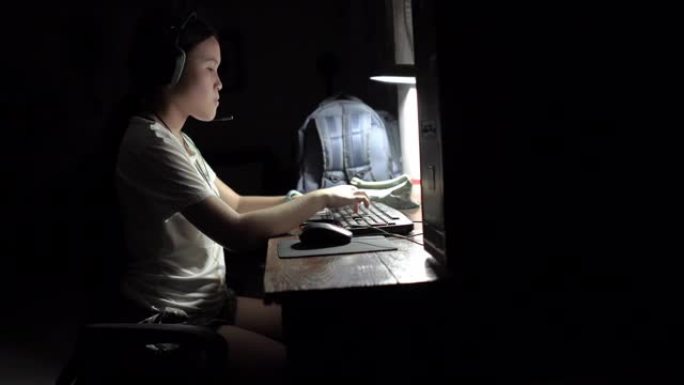 可爱的美丽的亚洲女孩用台式电脑靠在家里