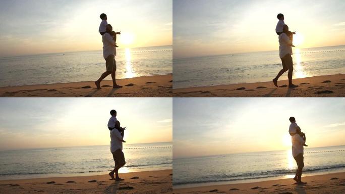 父亲和儿子在日出时在海滩上散步，他们一起度过了美好的家庭时光。用慢动作摄像机拍摄。