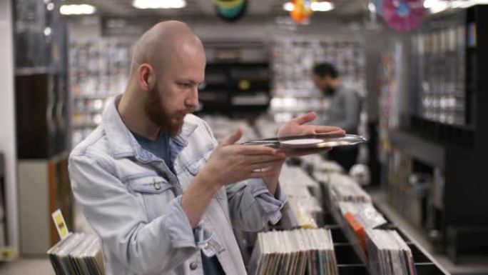 狂热的音乐收藏家在唱片店检查稀有的黑胶唱片