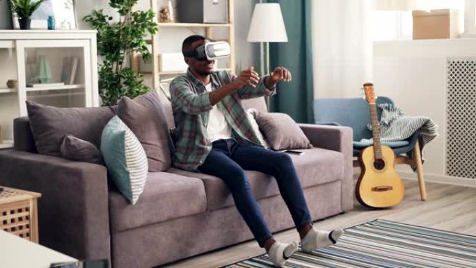 非裔美国人在家里戴着虚拟现实眼镜玩游戏