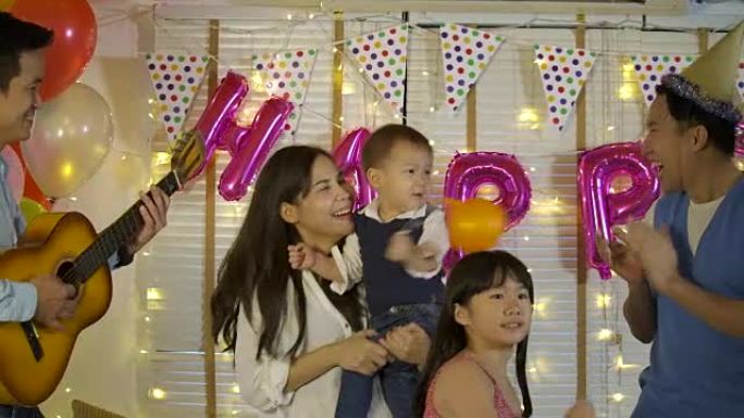 一群年轻的亚洲家庭在家里的派对活动中一起跳舞。快乐的家庭庆祝除夕。