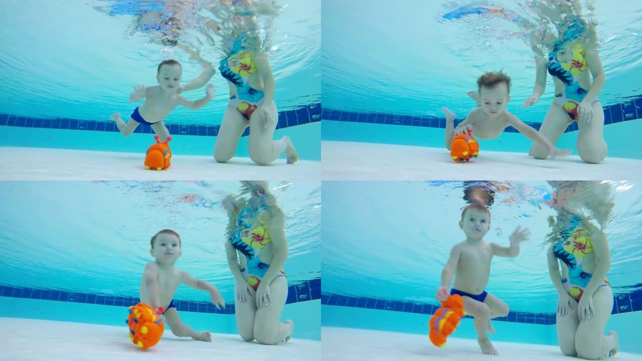 婴儿在妈妈的控制下从游泳池的水下拿起玩具