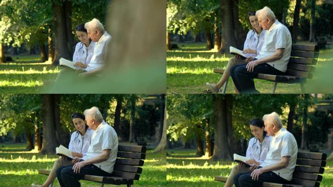 一个保姆，一个护士，照顾老人一个女孩 (女人) 和祖父坐在平装本上看书，在公园里。