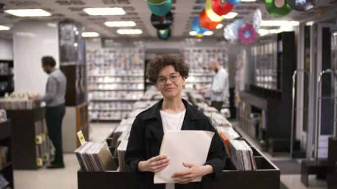 女性音乐收藏家在唱片店里摆着稀有的黑胶唱片