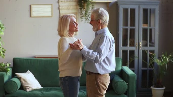 快乐浪漫的老夫妇在客厅跳华尔兹舞
