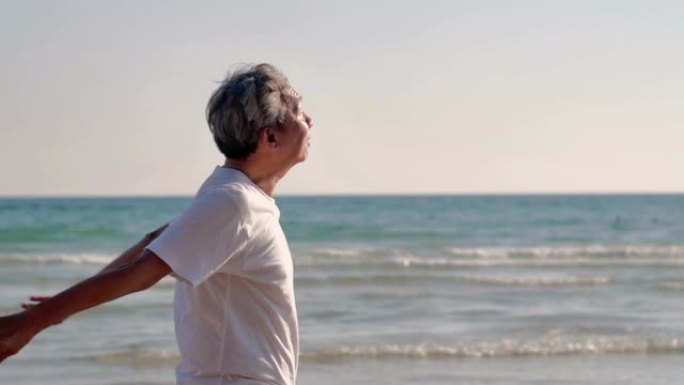快乐的老人退休后在海滩锻炼。日落时在海滩度假做伸展运动的高级男子。真实的身体