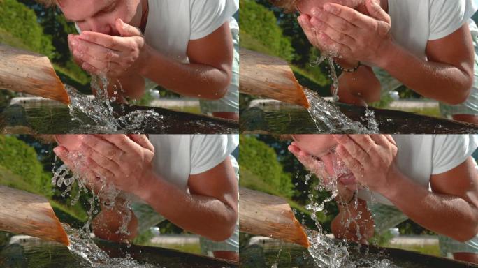 特写: 年轻男性通过向脸上泼水来冷却夏日的高温。