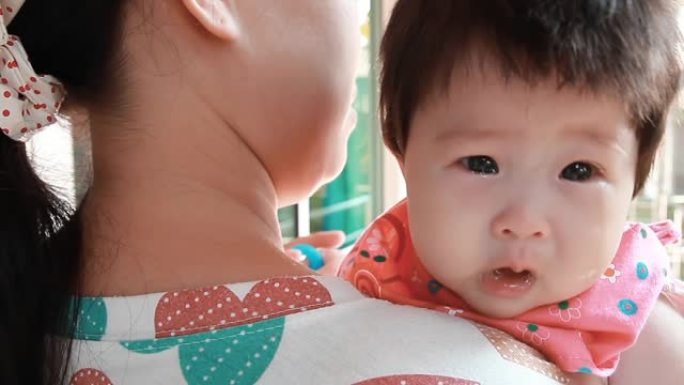 一个婴儿在母亲的怀抱中哭泣。