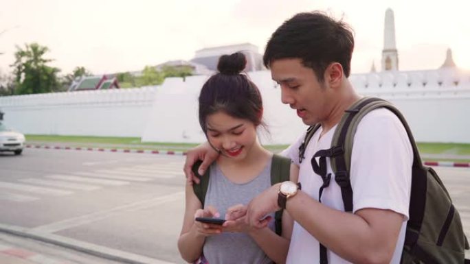 泰国曼谷地图上的亚洲旅行者夫妇方向，甜蜜的夫妇在日落时用手机在地图上看。生活方式夫妇在城市概念中旅行