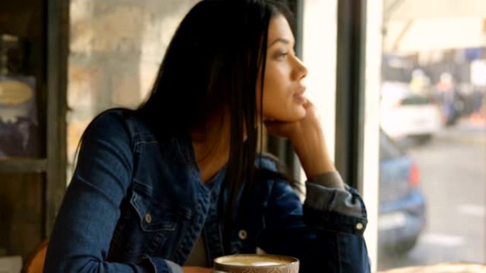 4k咖啡馆中年轻混血女子透过窗户看的前视图