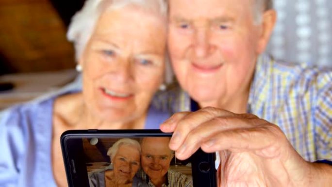 高加索老夫妇在舒适的家中用手机自拍的前视图4k