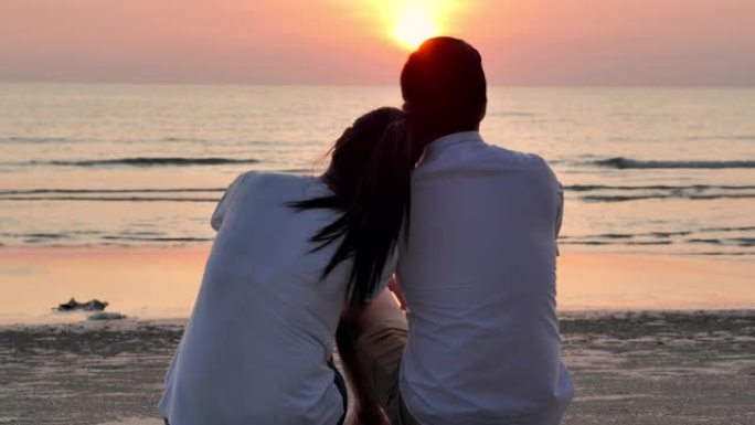 剪影夫妇坐在沙滩上的日落冲浪边缘，充满乐趣。家庭假期快乐。家庭，生活方式，人，人寿保险，假期，非高加