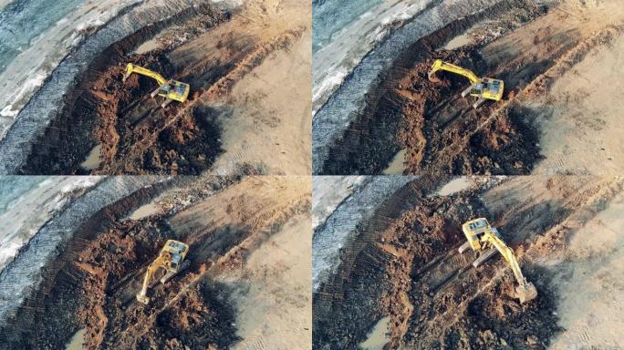 黄色挖掘机在采石场工作时移动泥土。工业建筑工地的重型机械。
