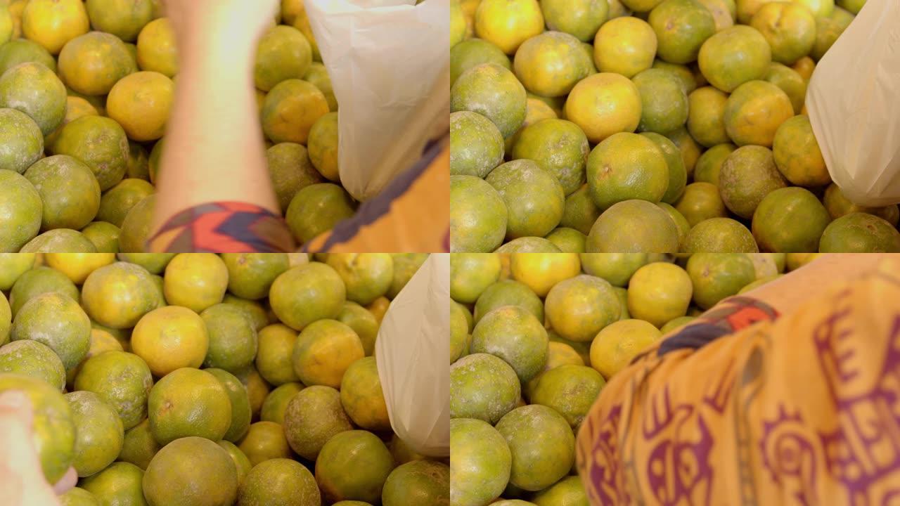 亚洲女人手选一只橘子在市面上