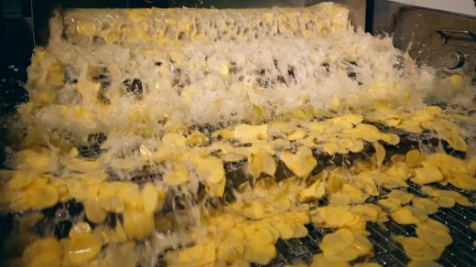 工作机器在一家食品工厂用油薯片油炸。