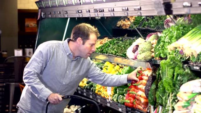 男子在超市的农产品过道中购物