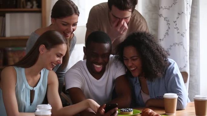 多种族的年轻朋友在智能手机上观看有趣的移动视频