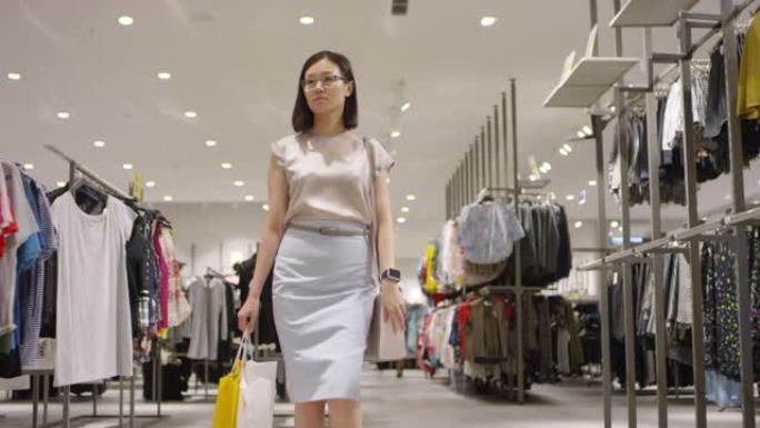中国女性购物者走过服装店