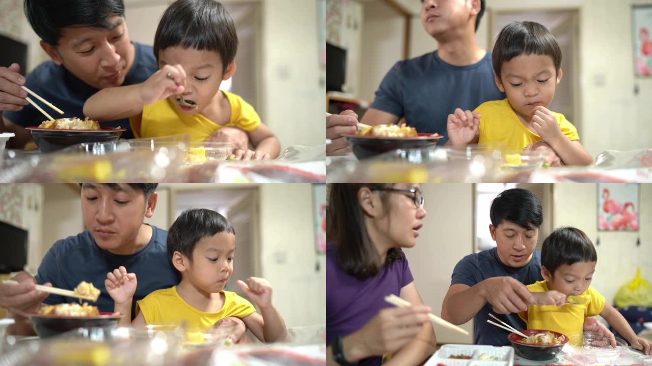 三岁的蹒跚学步的孩子自己在餐桌上吃食物