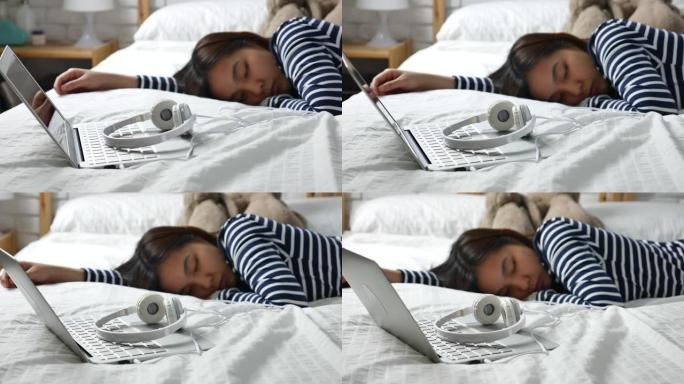 亚洲女性放松睡眠，用耳机听音乐