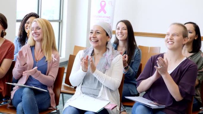 在乳腺癌认识会议上，一群妇女为励志演讲者鼓掌