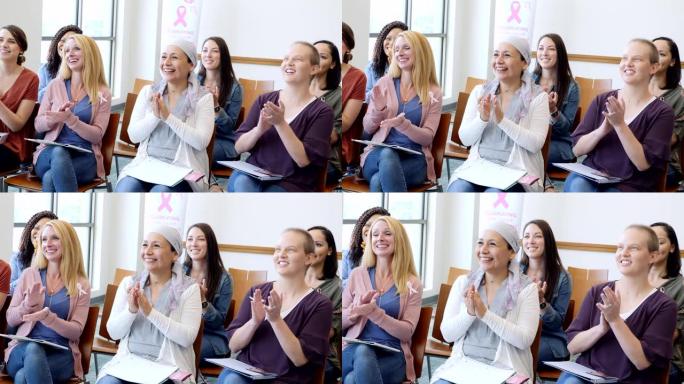 在乳腺癌认识会议上，一群妇女为励志演讲者鼓掌