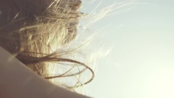 乘坐敞篷车时，女人的头发在风中吹动。特写