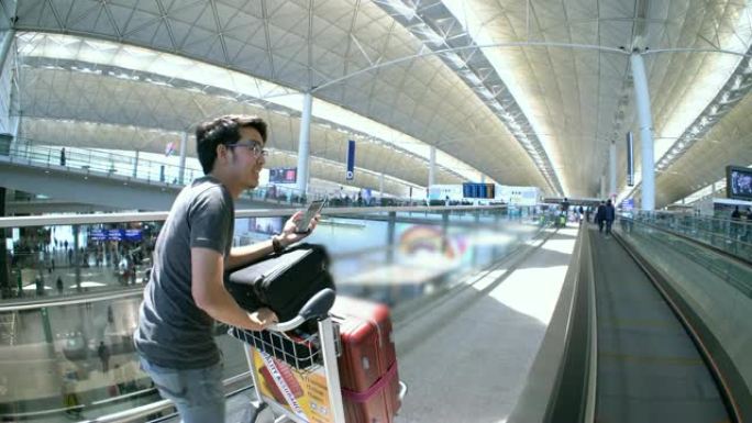 亚洲男子使用智能手机在机场办理登机手续
