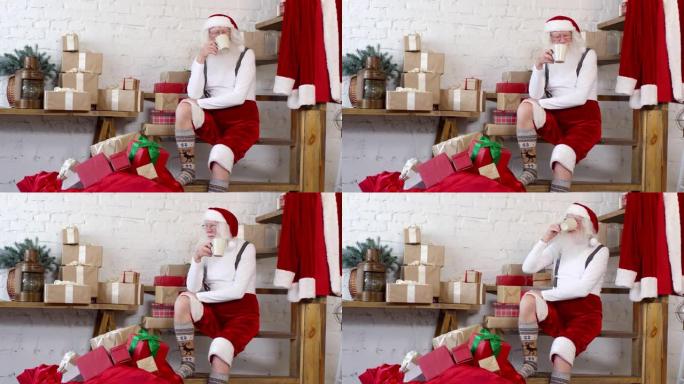 圣诞老人在家在木制楼梯上喝茶