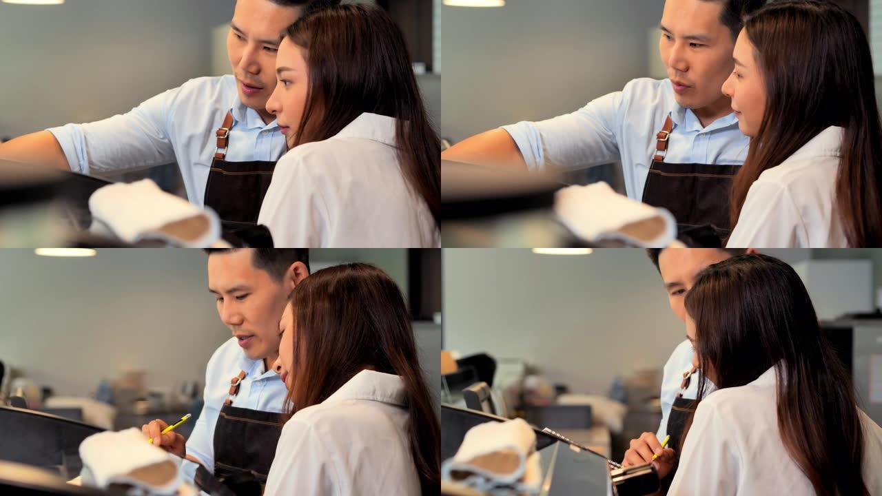 夫妇年轻的亚洲咖啡师在咖啡店的工作日感到快乐。商业，企业家，小企业，教育，成功理念
