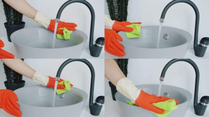 用湿布清洗浴室水槽的橡胶手套女性手的特写