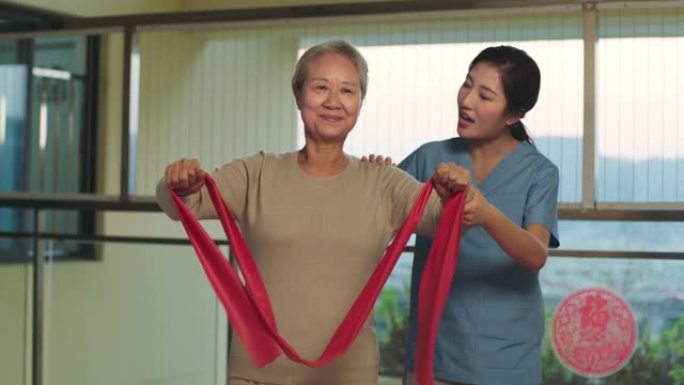 年轻的亚洲物理治疗师与高级患者一起工作