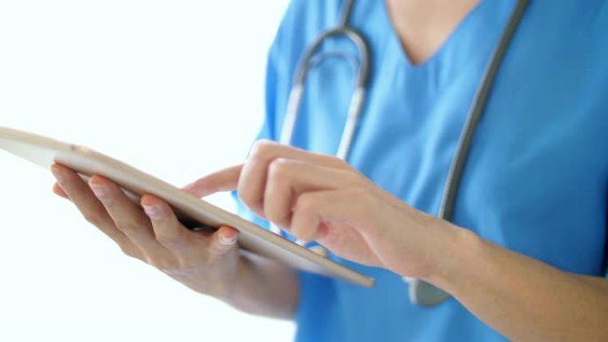 医院用数字平板电脑听诊器穿医生制服的女医生，慢动作