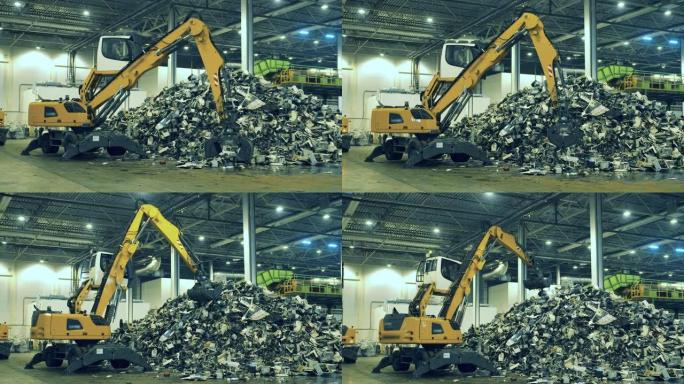 机械装载机正在抓取垃圾并将其放入一堆中。垃圾，塑料回收厂。